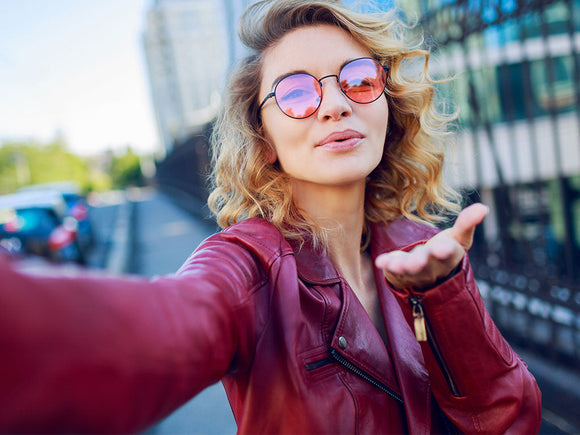 Selbstbewusste, fröhliche Frau lächelt in die Kamera