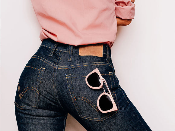 Frau trägt eine dunkle Jeans und ein Farbenfrohes, pinkes T-Shirt