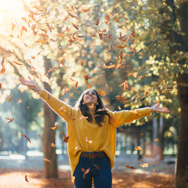 Herbstliches Bild mit Laub und Frau in Jeans