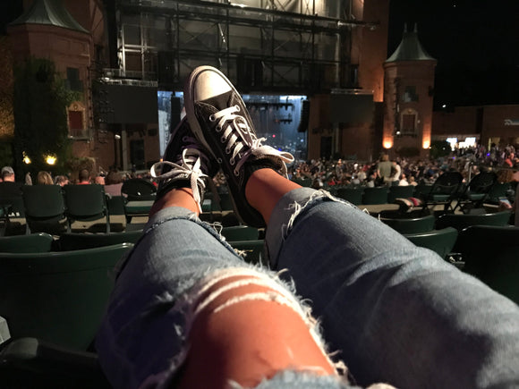 Frau trägt eine lässige Ripped Jeans auf einem Live-Konzert
